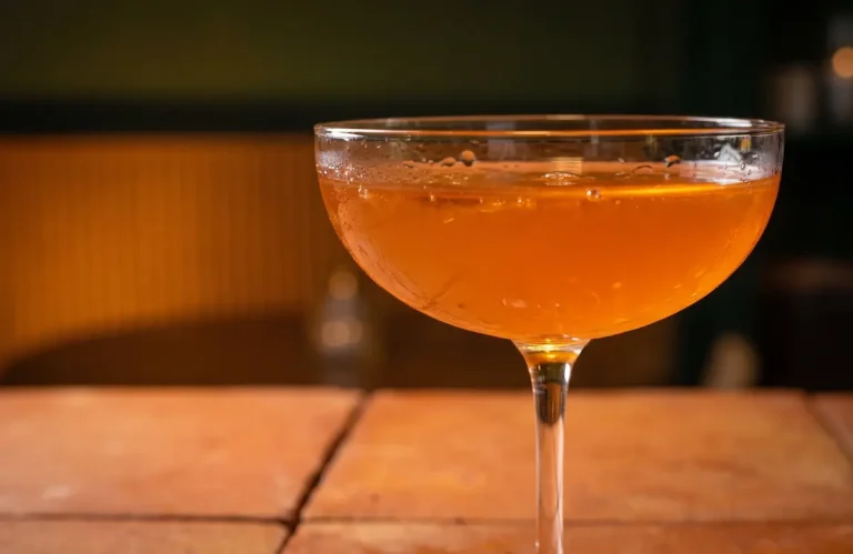 Admire the texture and perfection of this dazzling amber cocktail served in a coupe glass. A refreshing visual experience captured in maximum detail.