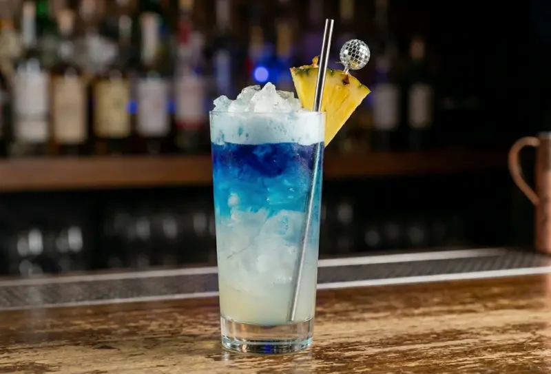 popolada ble float disco drink with blue float and tropical garnish layered popolada ble float disco drink with crushed ice, blue curaçao float and pineapple garnish