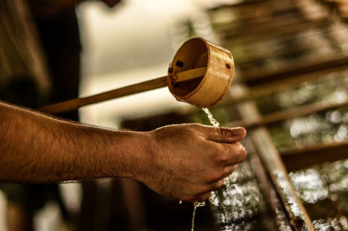 Mezcal being poured into hands during a traditional Oaxaca tasting ritual