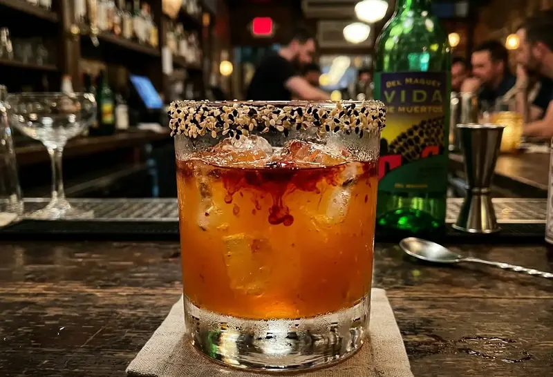 del maguey vida de muertos bottle with a signature smoky passion fruit cocktail in a bar setting with artisanal mezcal mixology